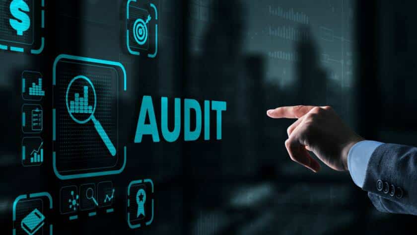 Main pointant vers une interface numérique avec le mot 'AUDIT' et des icônes représentant des graphiques et des cibles, illustrant l’usage de l’IA dans la LCB-FT.